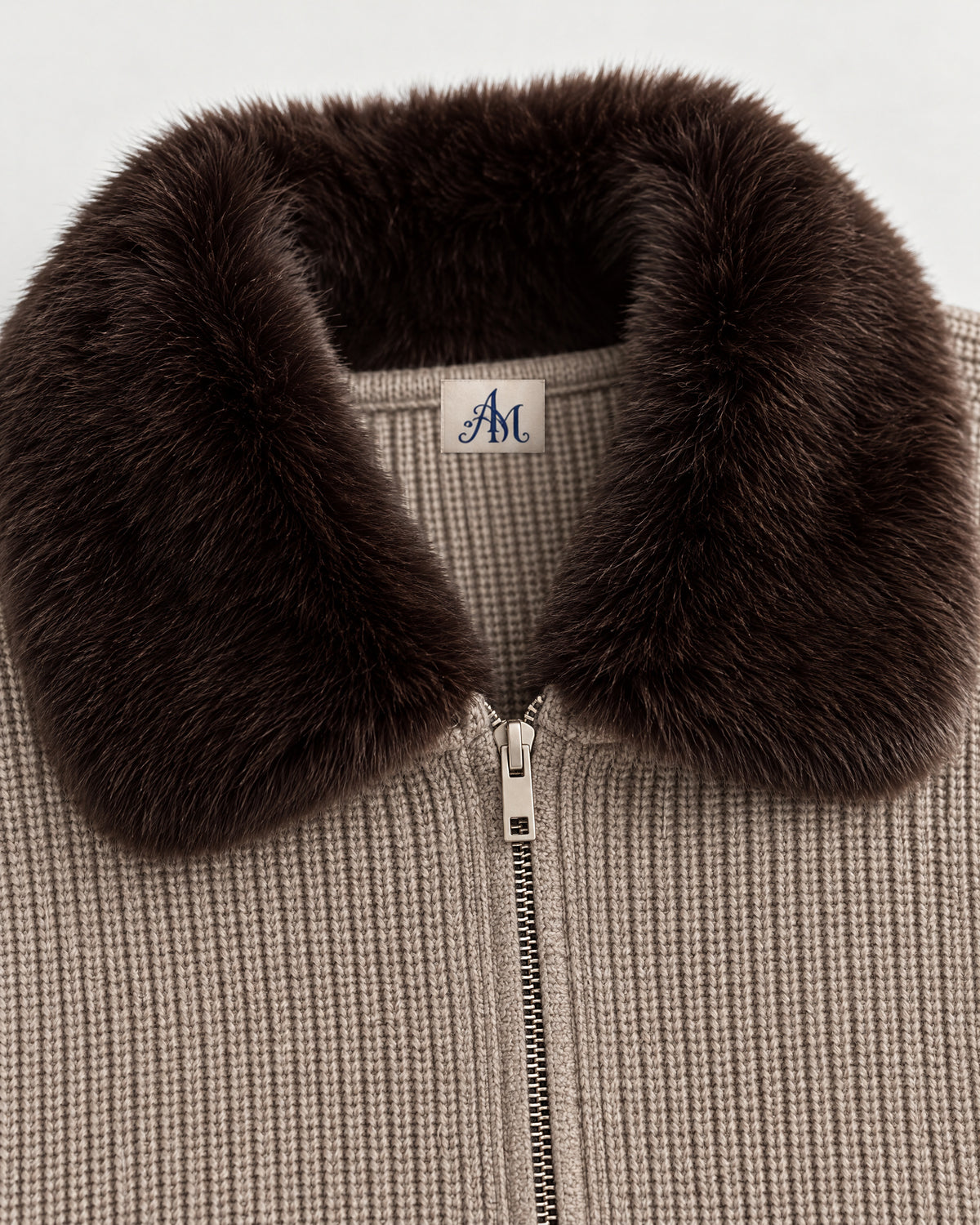 Detail: faux-fur collar and woven AM neck label