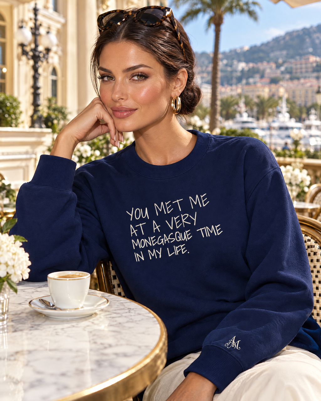 Model in navy Monegasque crewneck at a café terrace in Monte-Carlo